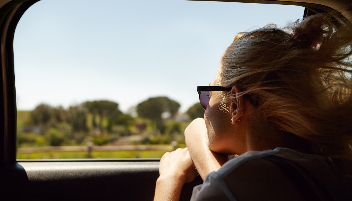 woman looking out the car window - travel nursing assignments